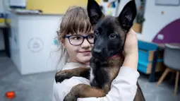 Nastya (9) memeluk seekor anjing bernama Barcelona selama sesi terapi anjing di Kyiv, Ukraina, Kamis, 26 Oktober 2023.