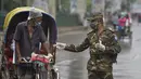 Tentara Bangladesh memeriksa seorang pria yang bepergian dengan becak di sebuah pos pemeriksaan sepanjang jalan Dhaka, Bangladesh, Kamis (1/7/2021). Tentara dan polisi diperintahkan untuk mencegah orang-orang keluar rumah, kecuali untuk keadaan darurat atau membeli kebutuhan pokok. (AFP/Munir Uz zam