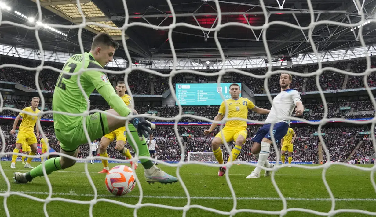 Pemain Inggris, Harry Kane, mencetak gol ke gawang Ukraina pada laga Kualifikasi Euro 2024 Grup C di Stadion Wembley, Minggu (26/3/2023). Inggris menang dengan skor 2-0. (AP Photo/Alastair Grant)