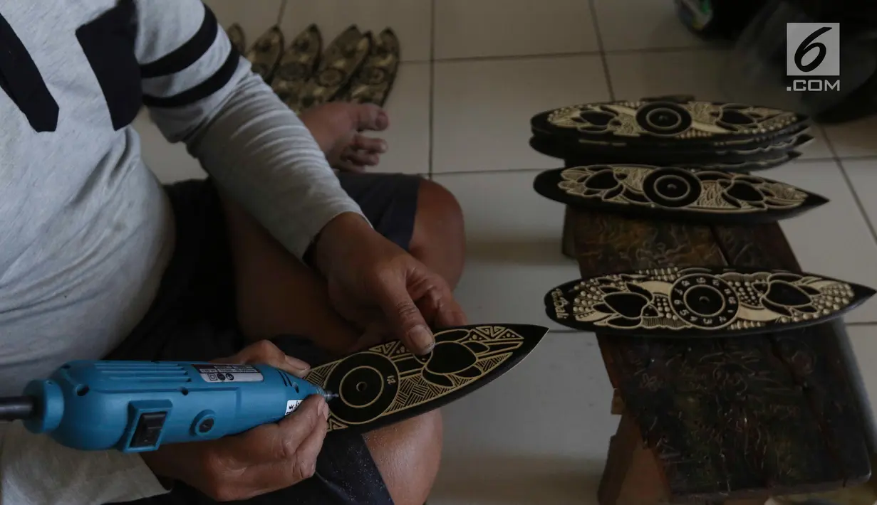 Pengrajin tengah membuat sovenir papan seluncur di Bali, Senin (15/10). Sektor pariwisata menjadi salah satu penyumbang cepat datangnya devisa. (Liputan6.com/Angga Yuniar)