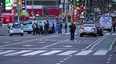 Petugas polisi terlihat sedang melakukan pemeriksaan di lokasi penembakan di Times Square di New York, AS (8/5/2021). Menurut laporan, tiga orang, termasuk seorang balita terluka dalam penembakan itu. (AFP/Kena Betancur)