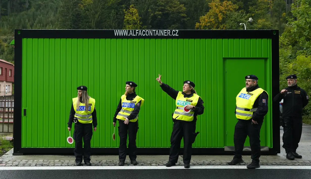 Polisi Ceko berdiri saat mereka memeriksa mobil dan truk di perbatasan dengan Slovakia di Stary Hrozenkov, Republik Ceko, Kamis, 29 September 2022. Kementerian itu mengatakan bahwa para pengungsi telah menggunakan Ceko sebagai negara transit dalam perjalanan mereka ke Barat. (AP Photo/Petr David Josek)