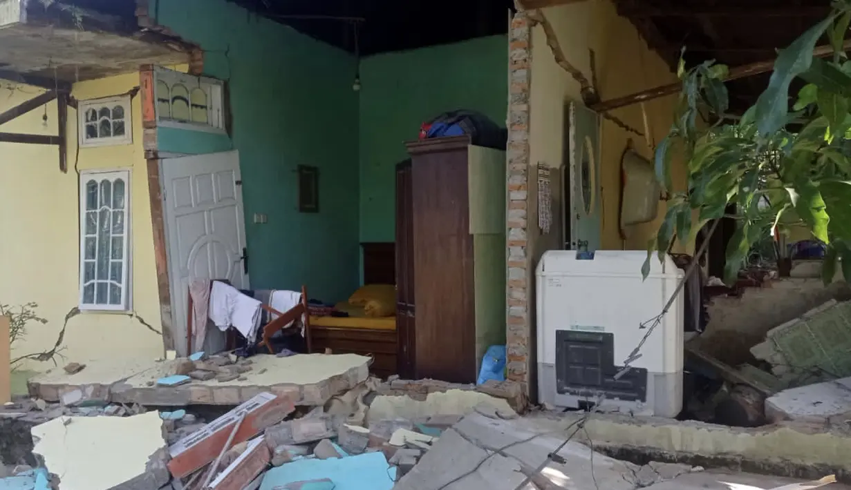 Kondisi rumah yang rusak setelah gempa Magnitudo 6,2 di Desa Kajai, Pasaman Barat, Jumat (25/2/2022). Sejumlah bangunan rusak akibat guncangan gempa. (IDENVI SUSANTO/AFP)