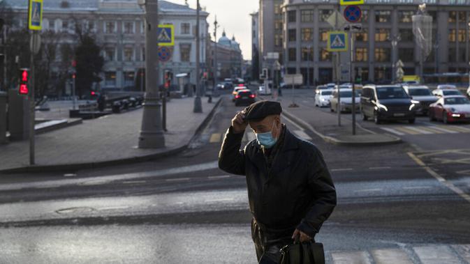 Seorang pria yang mengenakan masker untuk membantu mengekang penyebaran virus corona COVID-19 berjalan di Moskow, Rusia, Rabu (2/12/2020). Rusia memerintahkan penggunaan masker di seluruh negeri dan sebagian besar pembatasan ringan yang bervariasi. (AP Photo/Alexander Zemlianichenko)