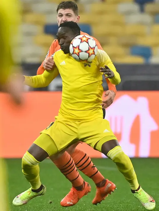 Pemain Shakhtar Donetsk Valeriy Bondar memperebutkan bola dengan pemain Sheriff Tiraspol Adama Traore pada pertandingan sepak bola Grup D Liga Champions di Stadion Olympiyskiy, Kyiv, Ukraina, 7 Desember, 2021. Pertandingan berakhir 1-1. (GENNYA SAVILOV/AFP)