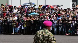 Antusiasme warga saat menyaksikan perayaan HUT ke-74 TNI di Lanud Halim Perdanakusuma, Jakarta Timur, Sabtu (5/10/2019). Warga rela panas-panasan dan berdesak-desakan untuk menyaksikan perayaan HUT ke-74 TNI. (Liputan6.com/JohanTallo)