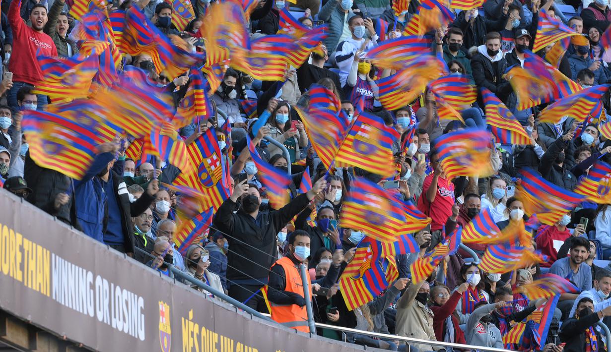 Camp Nou yang dipadati sekitar seribuan penonton menyambut kedatangan Xavi dengan kibaran bendera klub sambil mengelukan nama mantan kapten Barcelona tersebut penuh sukacita. (AFP/Lluis Gene)