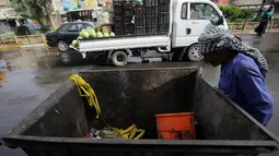 Seorang pekerja melihat tempat sampah yang berisi sisa-sisa pembom bunuh diri yang melakukan pengeboman semalam di Syiah Baghdad di al-Shoala (24/5). (AFP Photo/Ahmad Al-Rubaye)