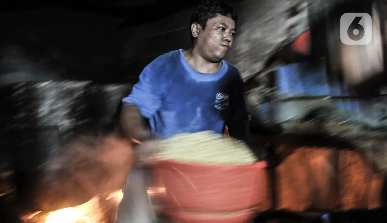 Perajin membawa rendaman biji kedelai yang akan diolahnya menjadi tempe di kawasan Sunter, Jakarta, Senin (4/1/2021). Perajin tempe setempat berupaya mengurangi kerugian akibat melonjaknya harga kedelai impor dengan memperkecil ukuran tempe dan menaikan harga jual. (merdeka.com/Iqbal S. Nugroho)