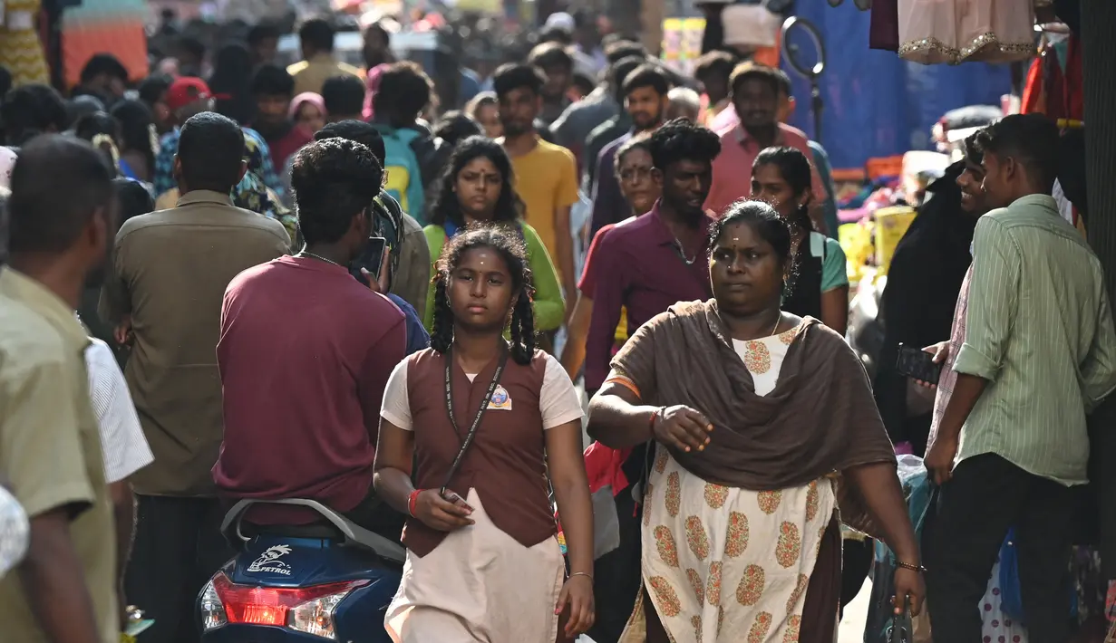 Orang-orang berjalan di sepanjang area pasar di Chennai, India pada 19 April 2023. India dalam jalur menuju negara berpenduduk terbanyak di dunia, melampaui China dengan selisih 2,9 juta orang pada pertengahan 2023, menurut data yang dilansir PBB hari Rabu (19/4). (Photo by Satish BABU / AFP)