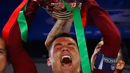Cristiano Ronaldo mengangkat tropi Piala Eropa 2016 usai memenangkan laga melawan Prancis di Stade de France, Senin (11/7). Ronaldo menorehkan sejumlah prestasi di ajang bergengsi tersebut. (REUTERS)