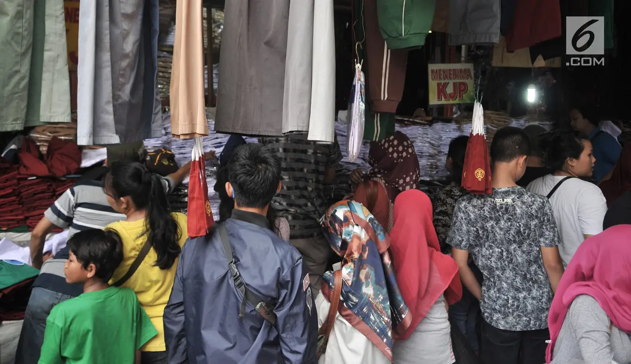 Para orangtua mencari seragam sekolah di Pasar Jatinegara, Jakarta, Minggu (14/7/2019). Jelang tahun ajaran baru, Pasar Jatinegara ramai didatangi para orangtua yang mencari seragam sekolah untuk anaknya. (merdeka.com/Iqbal Nugroho)