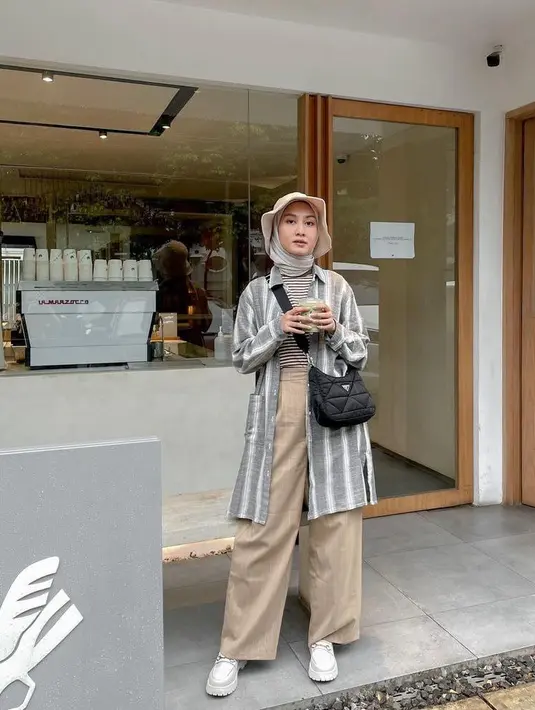 Cocok untuk hangout maupun liburan, kombinasi oversized shirt dengan stripes t-shirt dan wide leg pants juga tak kalah menarik untuk dicoba. (Instagram/inasrana).