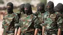 Pejuang dari Jaysh al-Izza (the Army of Glory) membentuk barisan saat melakukan latihan di kota Idlib, Suriah (9/4). Pejuang Jaish Al-Izzah merupakan bagian dari pasukan tentara pembebasan Suriah. (AFP/Omar Haj Kadour)