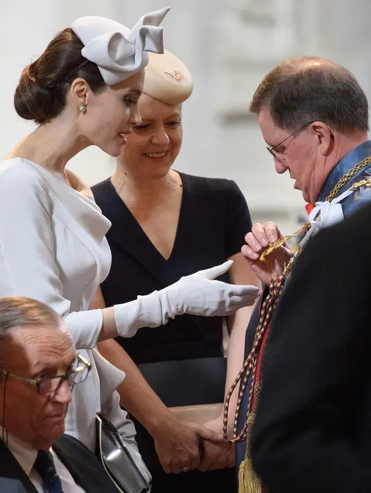 Aktris Angelina Jolie berbincang dengan Sekjen NATO, George Robertson dalam acara kebaktian di Katedral St. Paul, London, Kamis (28/6). Sebagai pelengkap penampilan, Angelina Jolie memakai topi berukuran kecil dengan aksesoris pita. (Leon Neal/PA via AP)