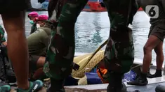 Tim selam Marinir TNI AL berhasil menemukan dan mengevakuasi serpihan pesawat Sriwijaya Air SJ 182 yang kemudian diserahkan ke Basarnas, Kepolisian, serta KNKT di Dermaga JICT 2, Jakarta, Minggu (10/1/2021). (Liputan6.com/Helmi Fithriansyah)