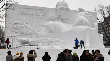 Sejumlah pengunjung melihat patung es Star Wars selama hari pembukaan Festival Salju Sapporo di Sapporo, Jepang (4/2). Festival Salju Sapporo dilangsungkan selama seminggu pada awal bulan Februari. (AFP Photo/Jiji Press)