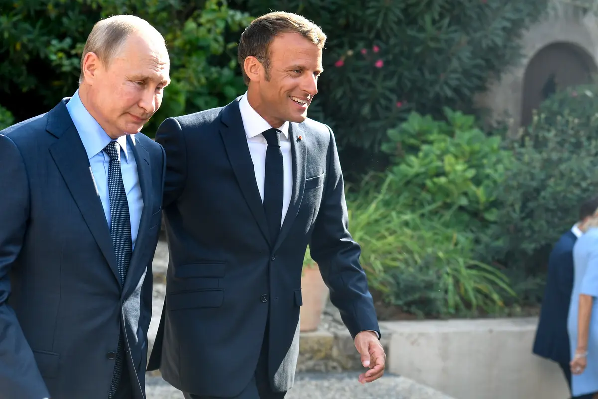 Sambil Berlutut, Putin Beri Bunga kepada Istri Presiden Prancis