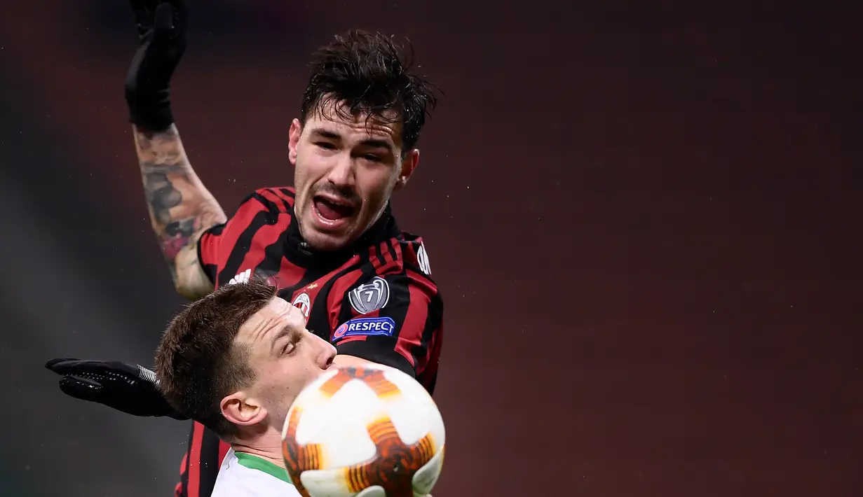 Bek AC Milan Alessio Romagnoli dan gelandang Ludogorets Razgrad, Gustavo Campanharo berebut bola pada leg kedua babak 32 besar Liga Europa, di San Siro, Milan, Kamis (22/2). Milan menang tipis 1-0 sehingga lolos ke babak 16 besar. (MARCO BERTORELLO/AFP)
