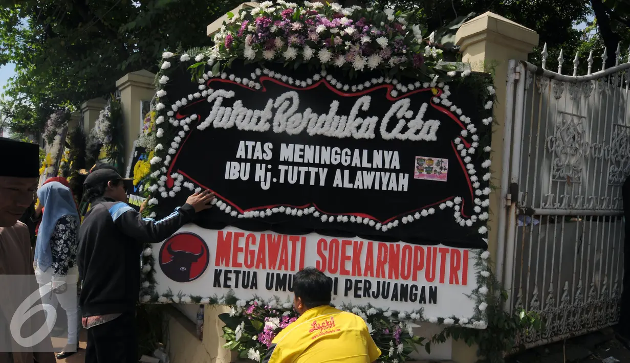 Karangan bunga duka cita dari Ketua Umum PDIP, Megawati Soekarnoputri terpajang di pintu rumah duka mantan Menteri Pemberdayaan Perempuan Tuty Alawiyah di Bekasi, Rabu (4/5/2016). TutyAlawiyah wafat di usia 74 tahun. (Liputan6.com/Helmi Fithriansyah)