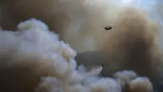 Sebuah helikopter berpartisipasi dalam operasi pemadaman kebakaran hutan di Koycegiz, Mugla, Turki, Senin (9/8/2021). Kebakaran hutan yang terjadi di tengah gelombang panas ganas telah berkobar selama berhari-hari di lebih dari setengah provinsi Turki. (AP Photo/Emre Tazegul)