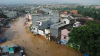 Sejumlah warga melintasi genangan banjir untuk mengungsi di jalan Raya Dayeuhkolot, Kabupaten Bandung, Minggu (13/3). Kawasan Bandung Selatan kembali dilanda banjir akibat luapan Sungai Citarum dan membuat ribuan orang mengungsi. (Timur Matahari/AFP)