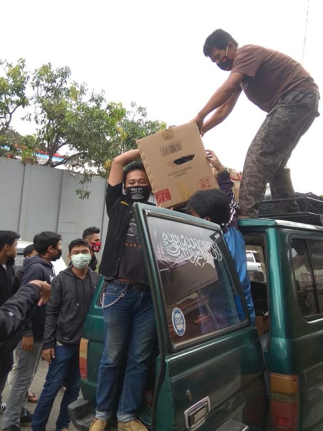 Puluhan remaja Solidarity Community (SC) 234 Garut, Jawa Barat, tengah bahu membahu menurunkan puluhan paket sembako yang akan dibagikan bagi masyarakat miskin perkotaan di Garut.