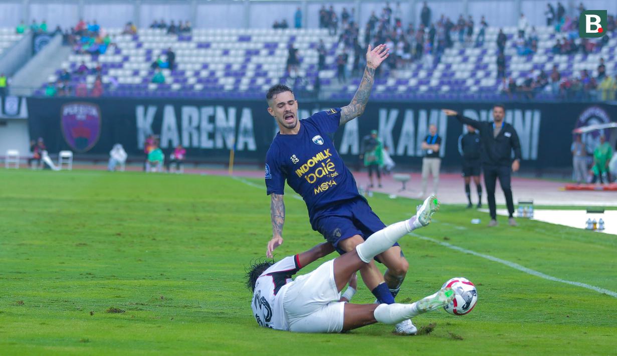 Pemain Persita Tangerang, Rayco Rodríguez, terjatuh saat berusaha melewati pemain Persik Kediri dalam laga lanjutan BRI Super League 2025/2026 di Stadion Indomilk Arena, Minggu (21/12/2025) sore WIB. (Bola.com/ M Iqbal Ichsan)