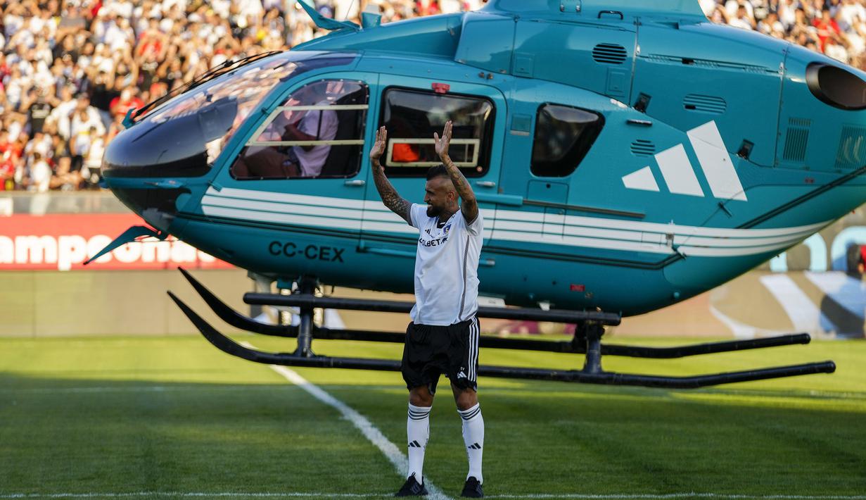 Arturo Vidal menyapa fans setelah turun dari helikopter saat acara perkenalan sebagai pemain baru klub Liga Chile, Colo-Colo di Stadion Monumental David Arellano, Chili, Jumat (2/2/2024) WIB. (AP Photo/Esteban Felix)
