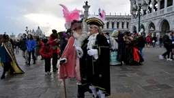 Sejumlah peserta mengenakan kostum dan topeng menari saat mengikuti Karnaval Venesia di Italia (27/1). Karnaval ini dimulai 40 hari sebelum hari paskah dan berakhir pada Mardi Gras, atau hari Rabu abu. (AFP Photo/Filippo Monteforte)