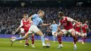 Pemain Manchester City, Erling Haaland, berusaha melewati pemain Arsenal pada laga Liga Inggris di Stadion Etihad, Kamis (27/4/2023). Arsenal takluk dengan skor telak 1-4. (AP Photo/Dave Thompson)