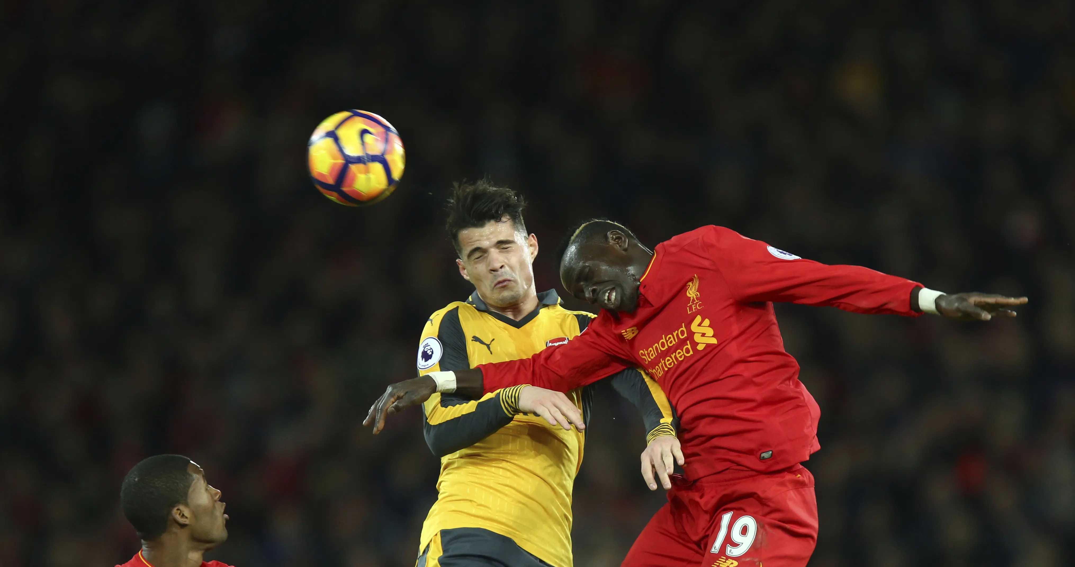 Pemain Arsenal, Granit Xhaka (tengah) berduel dengan pemain Liverpool, Sadio Mane (kanan) pada laga Premier League pekan ke-27 di Anfield, Liverpool, (4/3/2017). Liverpool menang 3-1. (AP/Dave Thompson)