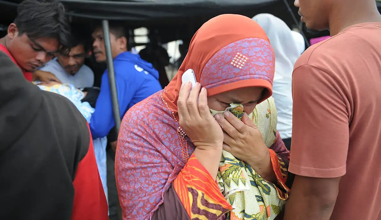 Seorang wanita menangis usai kerabatnya meninggal setelah gempa bumi di Pidie Jaya, Aceh, Rabu (7/12). Seperti dirilis BMKG, gempa berkekuatan 6,4 SR mengguncang Aceh sekitar pukul 05.03 WIB. (AFP PHOTO/Chaideer Mahyuddin)