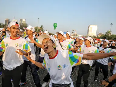 Warga mengikuti gerakan senam sembari menunggu prosesi Torch Relay Asian Games 2018 di Jakarta, Sabtu (18/8). Hari ini merupakan puncak kirab obor Asian Games 2018 dimana api abadi akan berlabuh di Gelora Bung Karno. (Liputan6.com/Faizal Fanani)