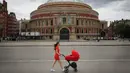 Seorang wanita berjalan melewati Royal Albert Hall di London, Inggris, Selasa (7/7/2020). Pemerintah Inggris akan menyalurkan paket bantuan sebesar 1,57 miliar poundsterling kepada industri seni, budaya, dan warisan untuk membantu mengatasi dampak pandemi COVID-19. (Xinhua/Tim Ireland)