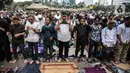 Massa aksi melaksanakan salat Ashar di sela unjuk rasa di Kawasan Patung Kuda, Jakarta, Selasa (13/10/2020). Massa aksi menolak Undang-Undang Cipta Kerja Omnibus Law tersebut salat beralaskan spanduk, kardus, hingga sajadah. (Liputan6.com/Faizal Fanani)
