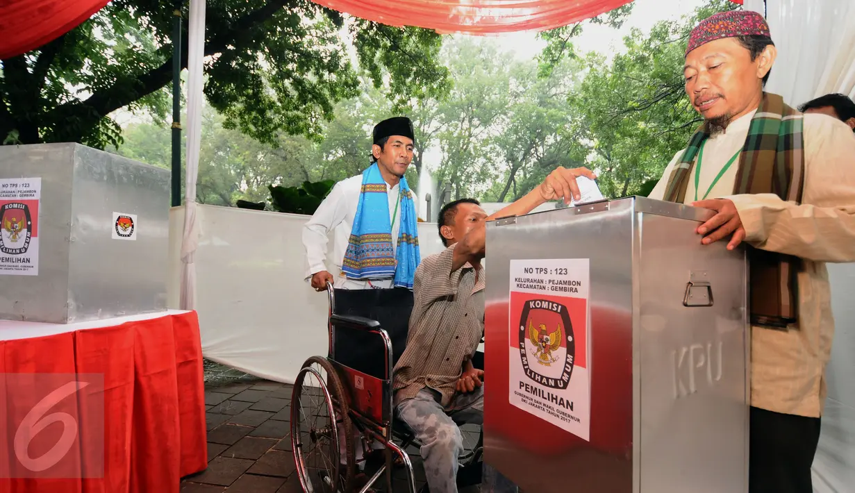 Petugas KPPS mengantar penyandang disabilitas memasukkan surat suara dalam simulasi pemungutan dan penghitungan suara Pilkada DKI Jakarta di Taman Menteng, Sabtu (28/1). Simulasi ini dilaksanakan oleh KPUD Jakarta Pusat. (Liputan6.com/Helmi Fithriansyah)