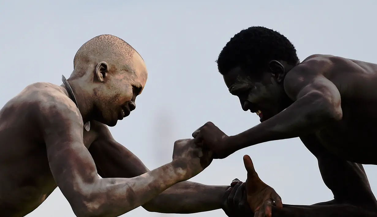 Dua pegulat bertarung sengit dalam Kompetisi Gulat Nasional Sudan Selatan di Stadion Juba, Sudan (20/4). Kompetisi gulat ini diselenggarakan dalam rangka untuk perdamaian. (CARL DE SOUZA / AFP)
