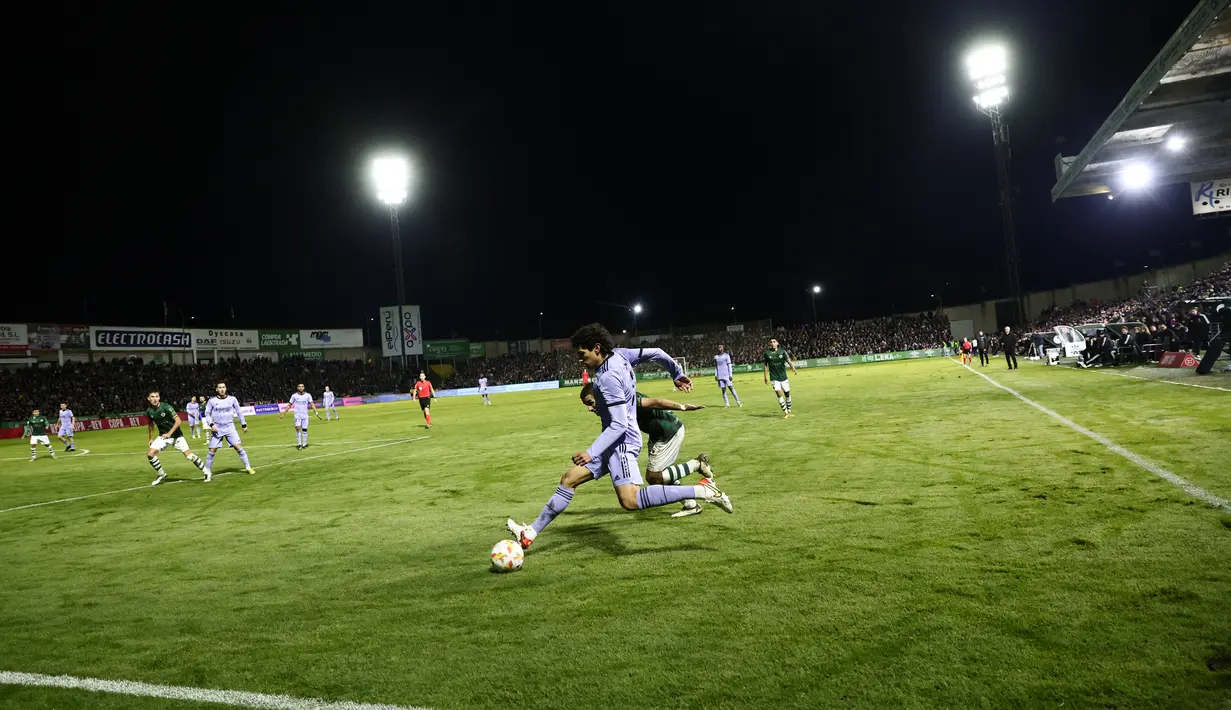 Bek Real Madrid, Jesus Vallejo berusaha mengumpan bola saat bertanding melawan Cacereno selama pertandingan babak 32 besar Copa del Rey di stadion Principe Felipe di Caceres, Spanyol, Rabu (4/1/2023). Kemenangan ini membawa Real Madrid melaju ke babak 16 besar Copa del Rey 2022-2023 menyusul tim-tim LaLiga lainnya seperti Espanyol, Valencia, dan Villarreal. (AP Photo/Pablo Garcia)