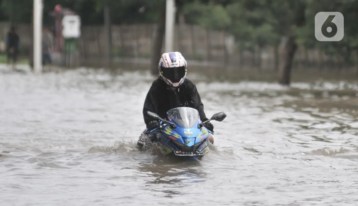 Pengendara sepeda motor nekat menerobos banjir di Jalan Ahmad Yani, Jakarta, Minggu (23/2/2020). Kondisi banjir yang lama surut memaksa pengendara motor nekat menerobos, namun kebanyakan dari mereka mengalami mogok. (merdeka.com/Iqbal S. Nugroho)