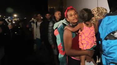 Para migran Venezuela menaiki bus yang akan membawa mereka ke tempat penampungan di kota Arica, Chile, Jumat (5/5/2023). (Photo by AGUSTIN MERCADO / AFP)