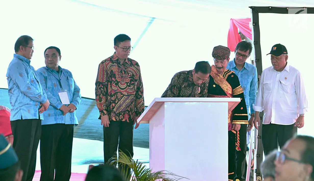 Presiden Jokowi menandatangani dokumen saat Hari Pers Nasional (HPN) 2018 di kawasan Danau Cimpago, Padang, Sumatera Barat, Jumat (9/2). Jokowi mencanangkan akan merevitalisasi seribu rumah gadang di Solok Selatan. (Liputan6.com/Pool/Biro Setpres)