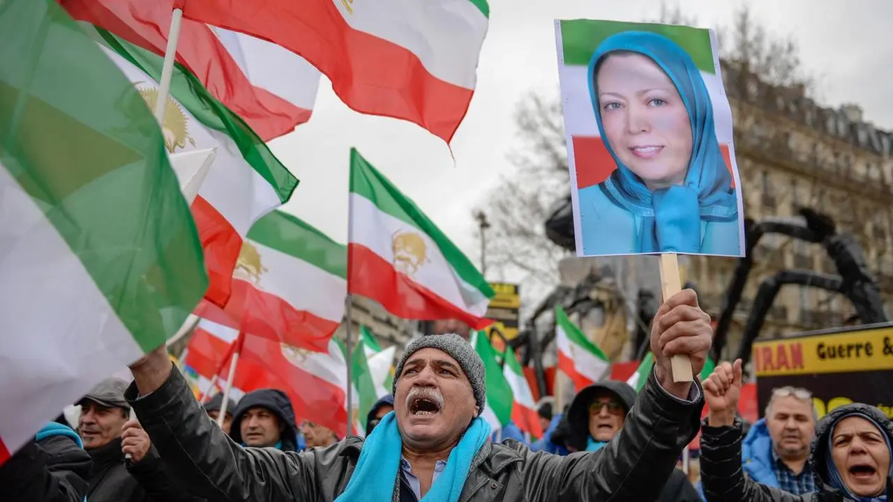 Anggota Mujahidin Iran atau MEK memegang bendera Iran era-Syah Pahlevi (sebelum Revolusi Islam) dan Pemimpin MEK Marjam Rajavi (AFP PHOTO)