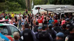 Polisi anti huru hara berjaga di pos pemeriksaan tempat kerabat dari para narapidana berkumpul menyusul kerusuhan yang terjadi di dalam penjara kota Amazon, Brasil, Senin (2/1). Setidaknya 60 orang tewas dalam kerusuhan di penjara (REUTERS/Michael Dantas)