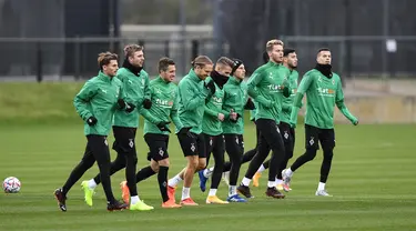 Para pemain Borussia Moenchengladbach melakukan pemanasan saat mengikuti latihan tim di Borussia-Park, Jerman (26/10/2020). Borussia Moenchengladbach akan bertanding melawan Real Madrid pada grup B Liga Champions. (AP Photo/Martin Meissner)