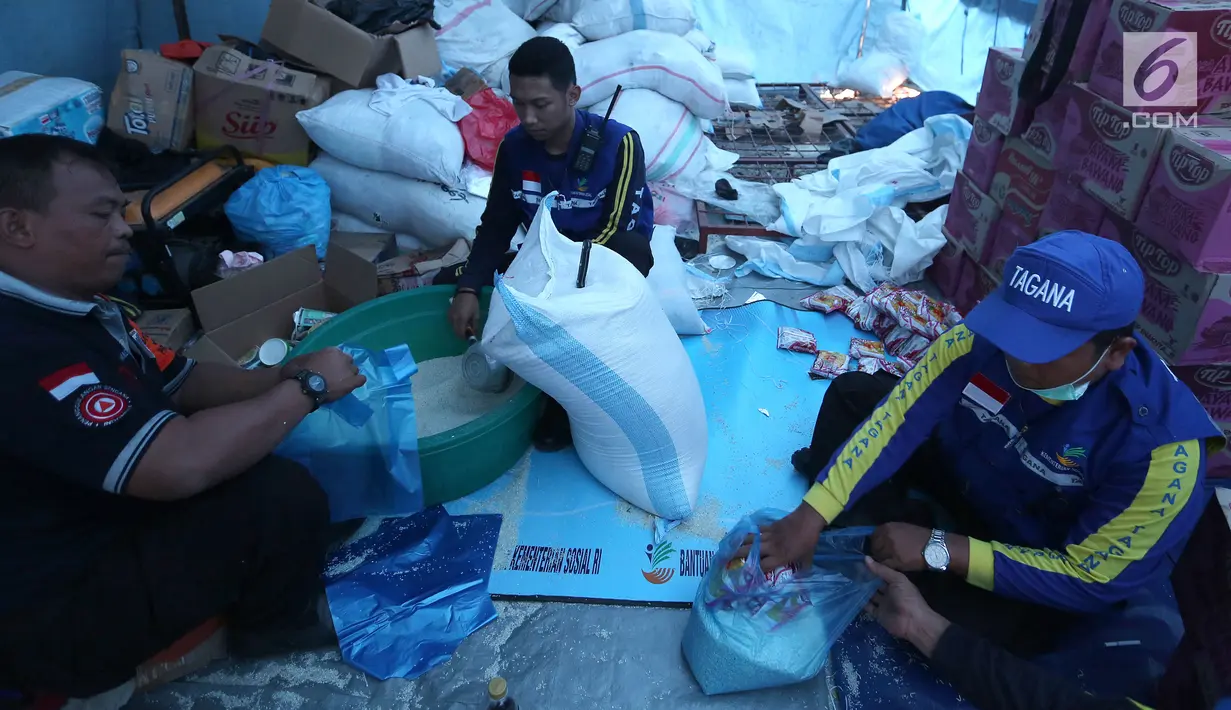 Relawan Tagana memasukan beras dan mie instan untuk Warga korban gempa dan tsunami Palu di kantor Dinas Sosial, Palu, Sulawesi Tengah, Minggu (7/10). Warga antre sejak pagi untuk mendapatkan bantuan yang disalurkan dari Dinsos. (Liputan6.com/Fery Pradolo)