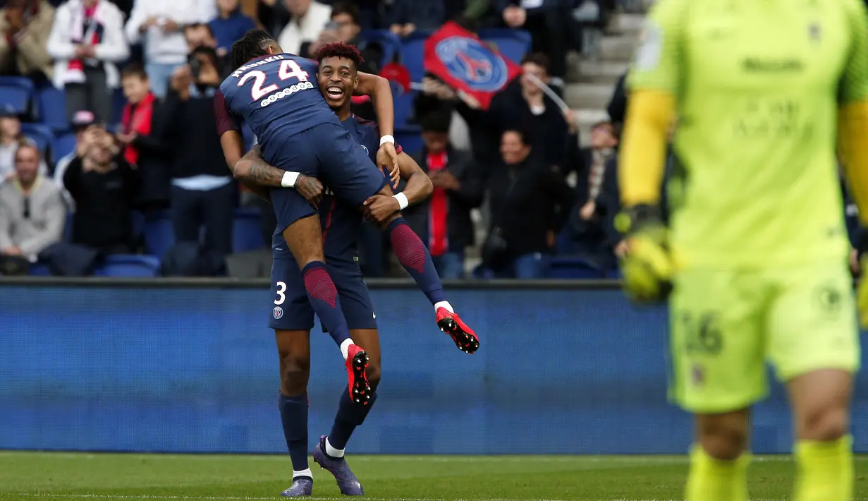 Aksi pemain PSG, Presnel Kimpembe mengnangkat rekannya Christopher Nkunku usai membobol gawang FC Metz pada lanjutan Ligue 1 Prancis di Parc des Princes Stadium, Paris (10/3/2018). PSG menang telak 5-0. (AP/Thibault Camus)