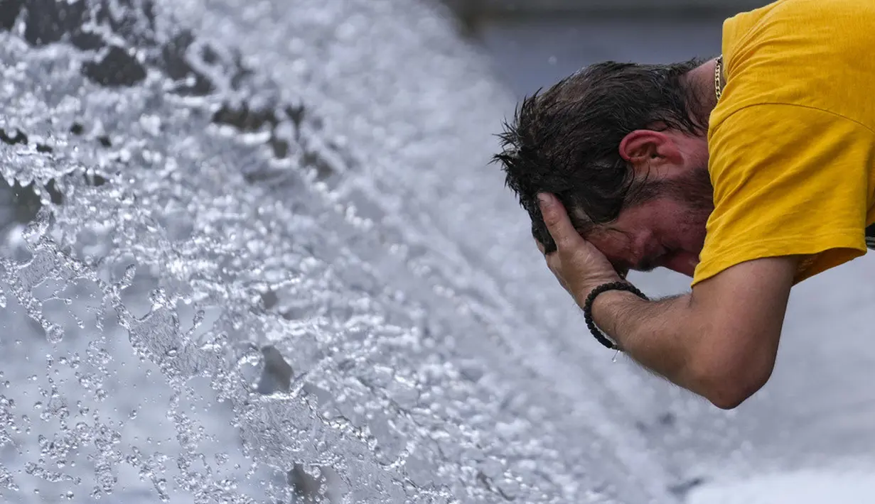<p>Seorang pria mendinginkan diri di air mancur saat hari cerah di Beograd, Serbia, 13 Juli 2023. Cuaca panas telah terjadi dengan suhu naik hingga 38 Celcius (100,4 Fahrenheit) di Beograd. (AP Photo/Darko Vojinovic)</p>