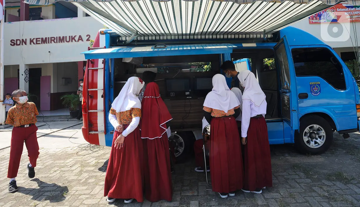 Siswa SDN Kemirimuka 2 Depok menggunakan internet sehat pada Operator Mobile Community Acces Point (M-CAP) di  Depok, Jawa Barat, Kamis (28/7/2022). Sosialisasi yang dilakukan Dinas Komunikasi dan Informatika (Diskominfo) itu diharapkan dapat meningkatkan kemampuan anak-anak khususnya di bidang teknologi informasi. (merdeka.com/Arie Basuki)