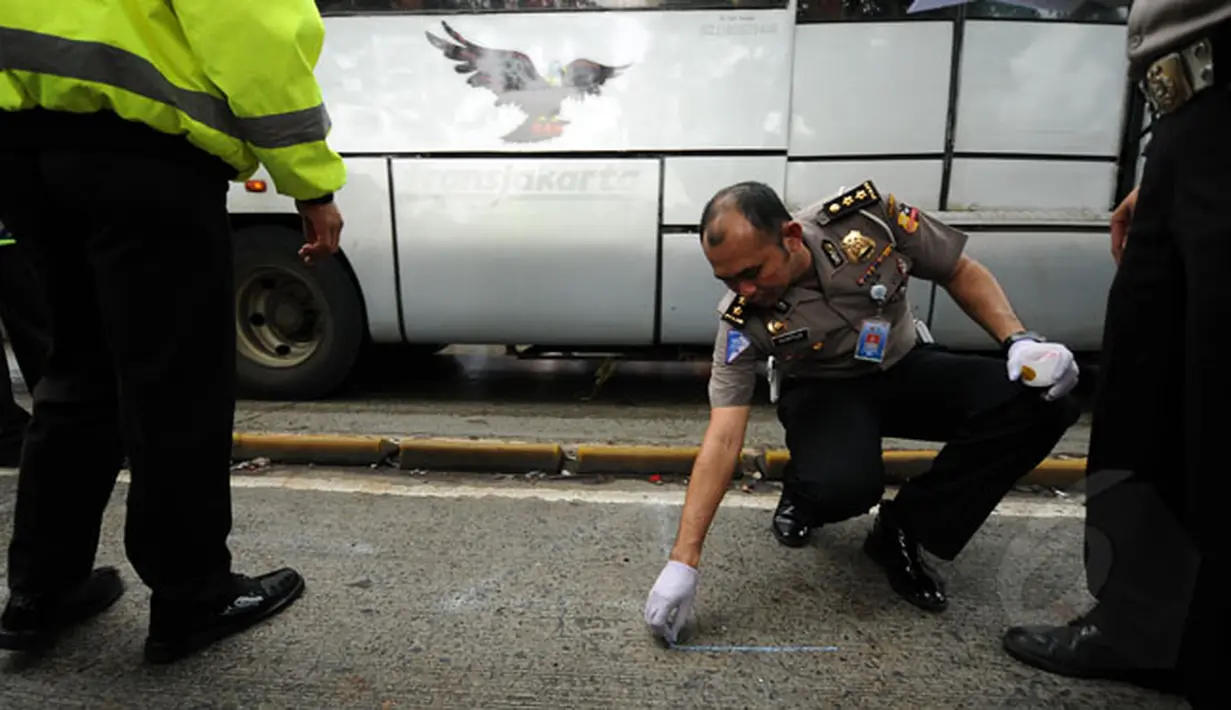 Seorang anggota polisi menandai salah satu lokasi kejadian kecelakaan maut di ruas Jalan Sultan Iskandar Muda, Pondok Indah, Jakarta, Kamis (22/1/2015). (Liputan6.com/Helmi Fithriansyah)